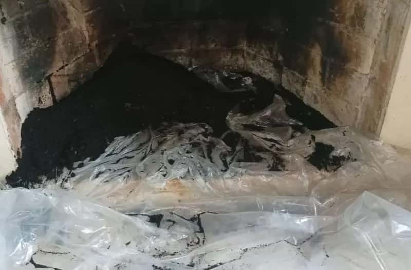 Acumulación de hollín en la base del ducto de un hogar a leña