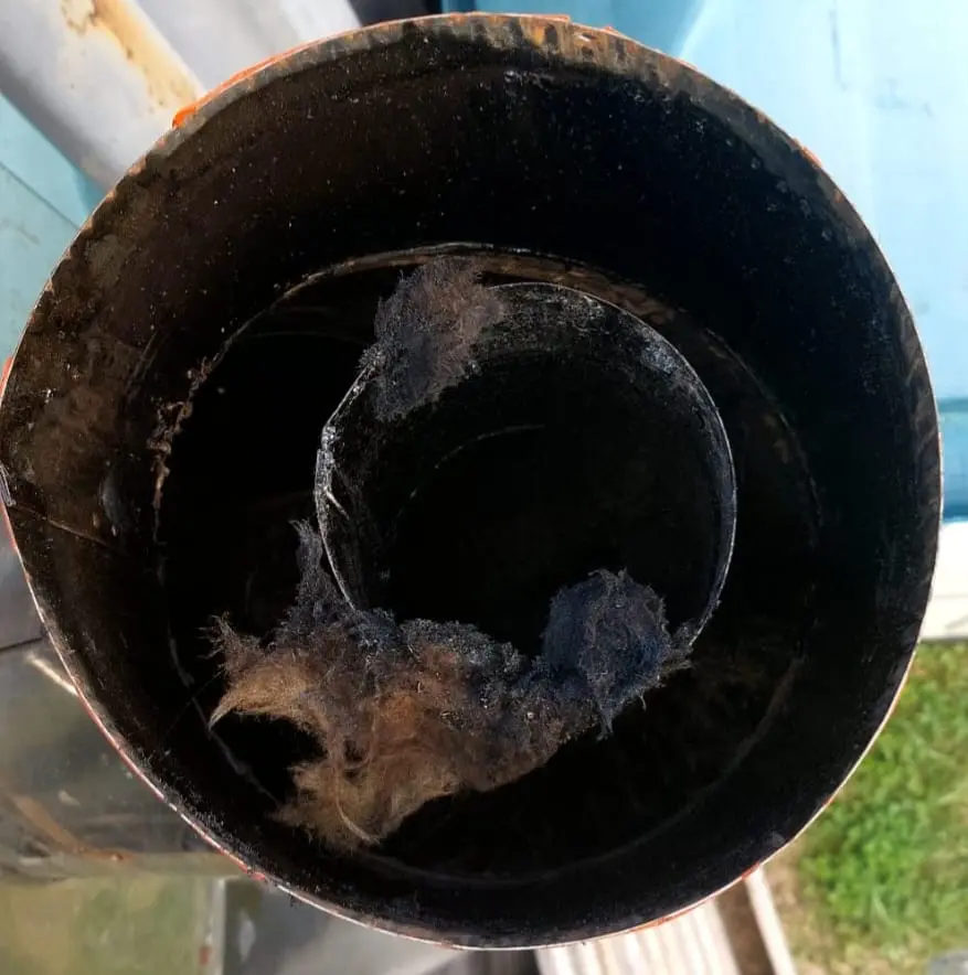 Ducto parcialmente obstruido por acumulación de hollín