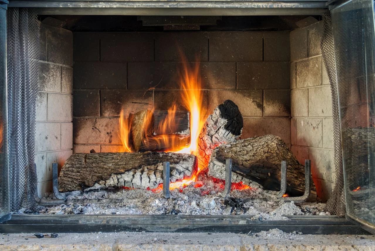 Interior de una chimenea con ceniza acumulada y paredes sucias — señal de que necesita limpieza